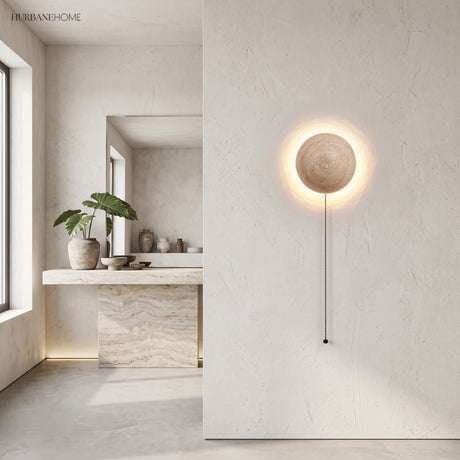 Stone wall sconce with pull-cord glowing in a bright minimalist interior