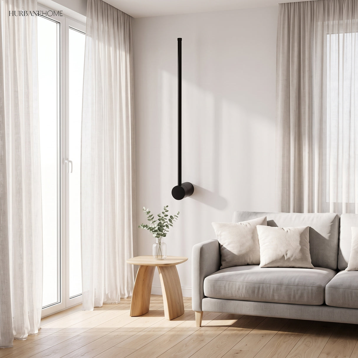 Single vertical black linear wall light beside a grey sofa in a living room