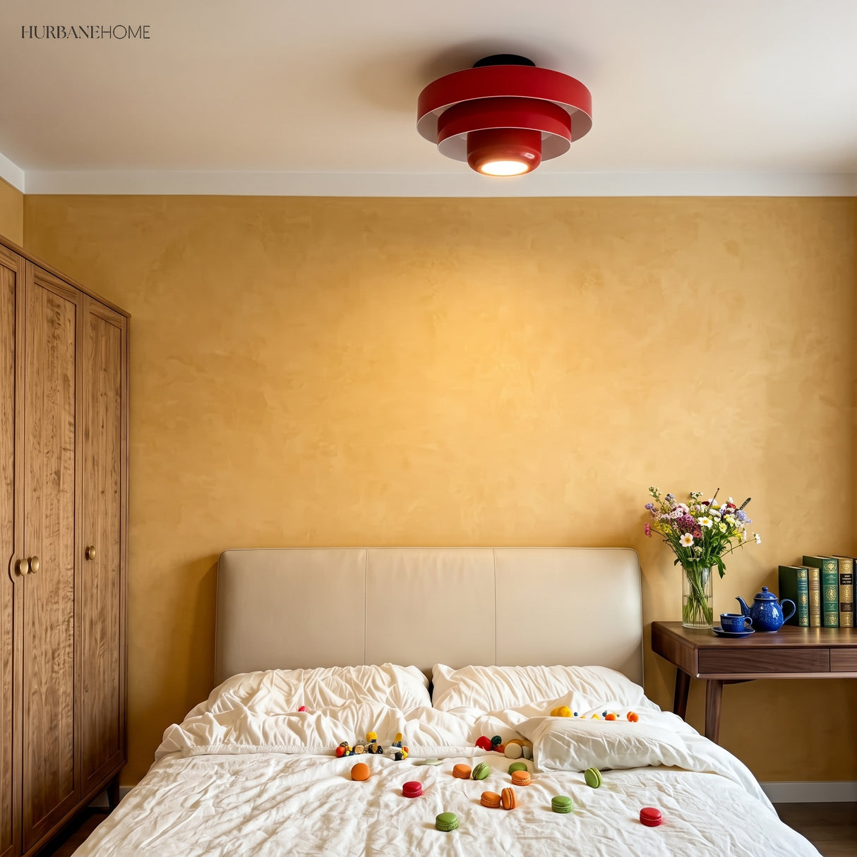Red tiered ceiling light in a warm yellow bedroom above a bed
