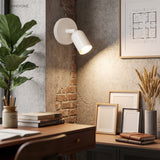White modern wall sconce on an exposed brick corner above a home office desk