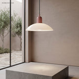 Cream disc pendant light near a tall window with a garden view