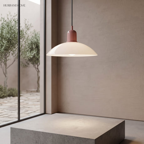 Cream disc pendant light near a tall window with a garden view