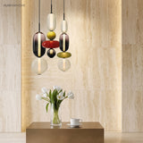 Colorful glass pendant light with red disc above a home office desk
