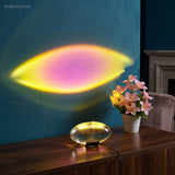 Ambient lamp projecting a pink and gold oval glow on a wall