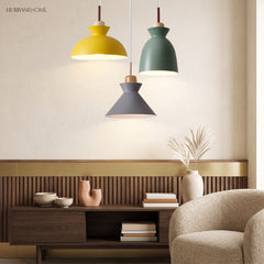 Yellow, green and grey pendant lights grouped above a walnut sideboard and armchair