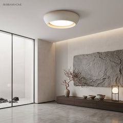 White cement ceiling light in a calm Japandi space beside a glass rock garden