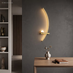 Gold arc wall light with frosted acrylic globe beside a wooden desk