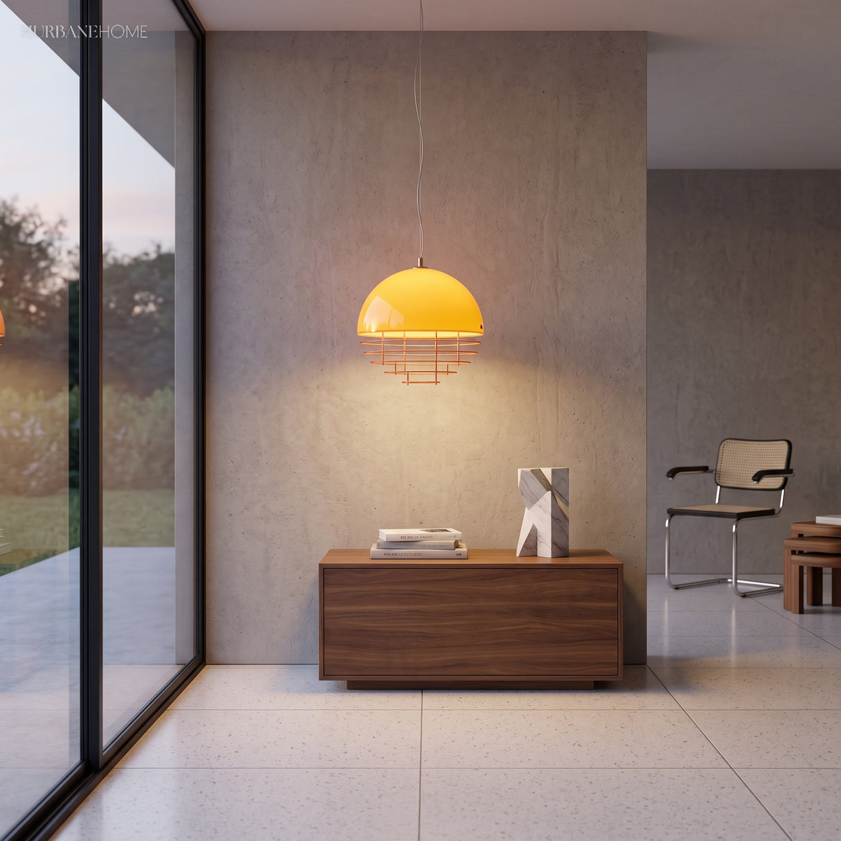 Lit orange pendant with layered discs hanging over a walnut sideboard against a concrete wall