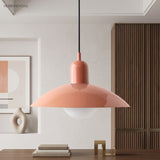 Coral pink dome pendant light above a console with framed wall art