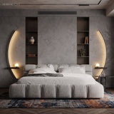 Two black crescent LED sconces flanking a bed in a grey bedroom