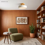 White wood ceiling light in a wood-panelled reading nook with a green chair