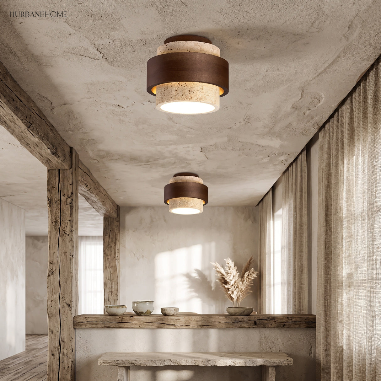 Two tiered travertine ceiling lights over a reclaimed timber bench in a plaster kitchen