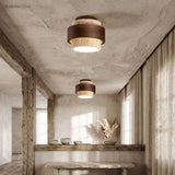 Two tiered travertine ceiling lights over a reclaimed timber bench in a plaster kitchen