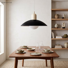 Modern disc pendant light hanging in a bright minimalist living corner