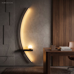 Black minimalist crescent LED sconce lighting a warm walnut home office wall