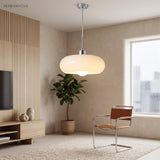 Warm orange glass pendant light casting a soft glow over a study desk