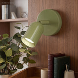 Angled view of the wall sconce beam highlighting art beside a shelf display