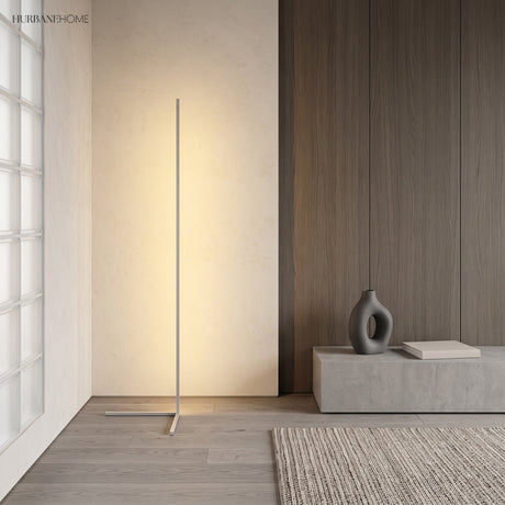 White corner floor lamp casting soft ambient light against a wood panelled wall
