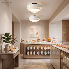 Green tiered ceiling light casting soft light in a neutral interior