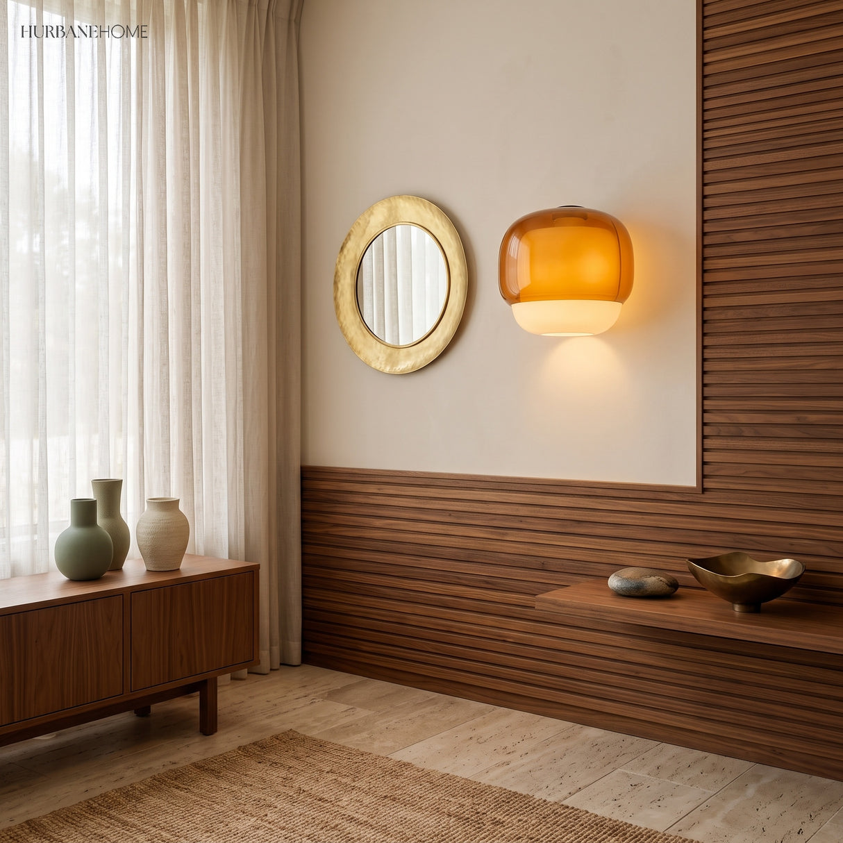 Amber wall sconce beside a round mirror on warm walnut slat panelling