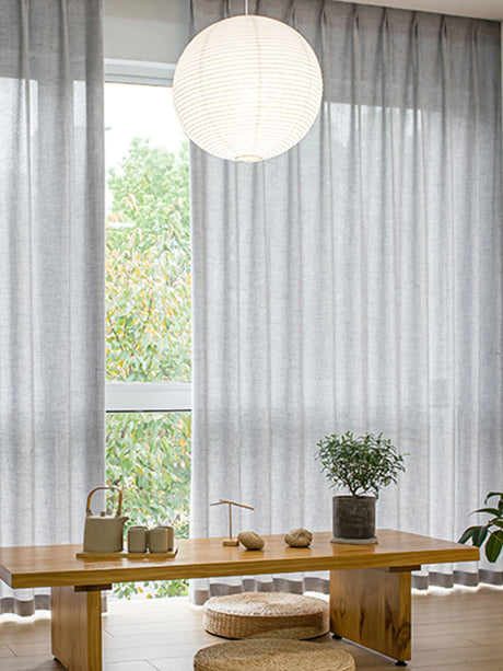 Light filtering semi sheer curtains hanging over large bedroom window