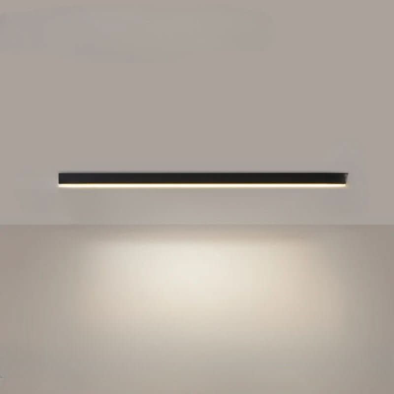 Black linear LED bar light on a ceiling above a minimalist room
