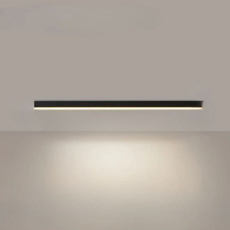 Black linear LED bar light on a ceiling above a minimalist room