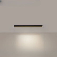 Black linear LED ceiling bar photographed against a pale ceiling