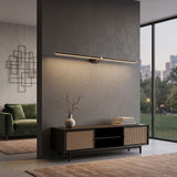Slim linear LED wall sconce above a cane sideboard in a modern lounge