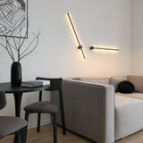 Two angled black wall lights above a grey sofa and black side table