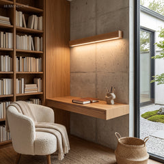 Wood wall light lit above a framed mirror in a panelled timber bathroom