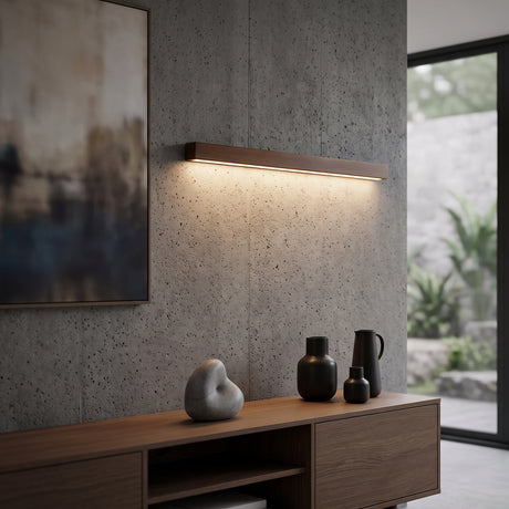 Walnut linear wall light lit above a timber vanity and framed bathroom mirror
