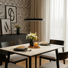Black disc pendant lit warmly to show its even glare free output