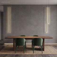 Black linear pendant lights flanking a grey wall over a wood dining table