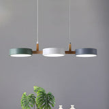 Studio view of green, white and grey drum shades linked by a wood bar