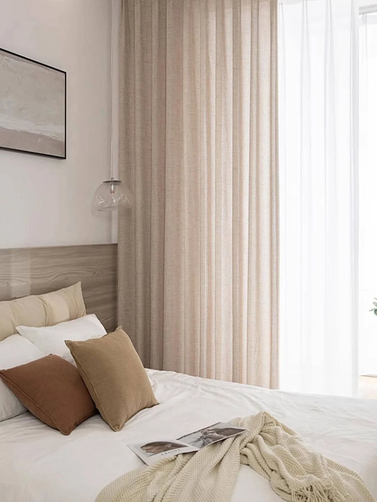 Linen blend light filtering curtains draped over wide bedroom window