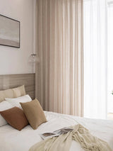 Linen blend light filtering curtains draped over wide bedroom window