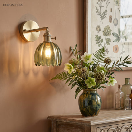 Amber lotus glass sconce above a console with flowers and books