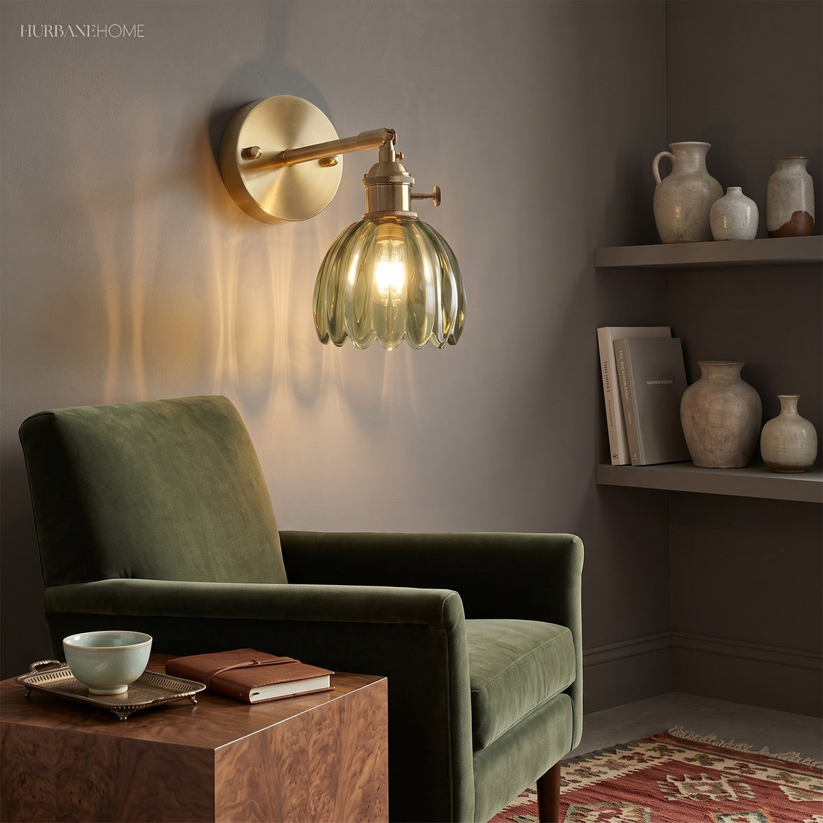 Green lotus glass wall light beside a velvet armchair and shelving