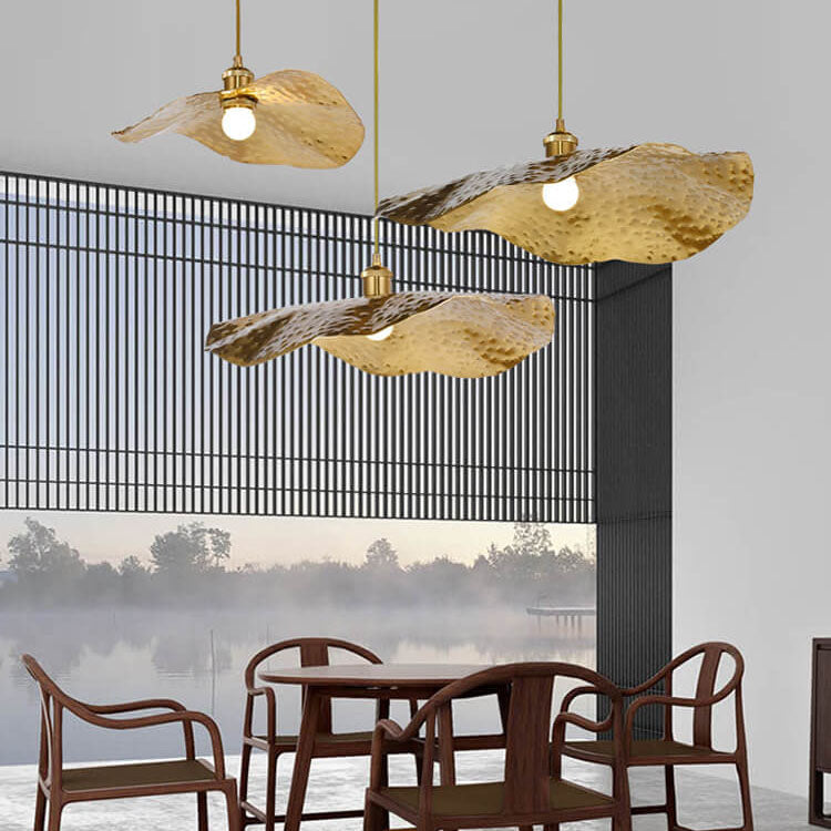 Three lotus leaf pendants hanging at staggered heights near a lakeside window