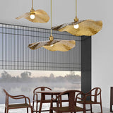 Three lotus leaf pendants hanging at staggered heights near a lakeside window