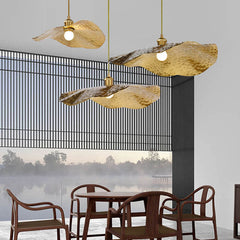 Three lotus leaf pendants hanging at staggered heights near a lakeside window