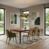 Sage green lotus pendant light over a wood dining table with green art
