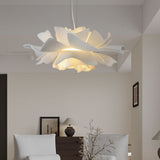 White flower pendant light in a living room with armchairs and a lamp