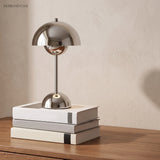 Chrome table lamp on stacked books on a timber sideboard