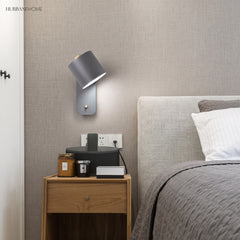 Rotatable cylinder wall sconce in a styled bedroom