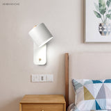 Rotatable cylinder wall sconce in a styled bedroom