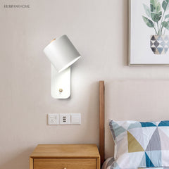 Rotatable cylinder wall sconce in a styled bedroom