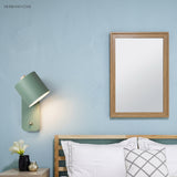 Rotatable cylinder wall sconce in a styled bedroom