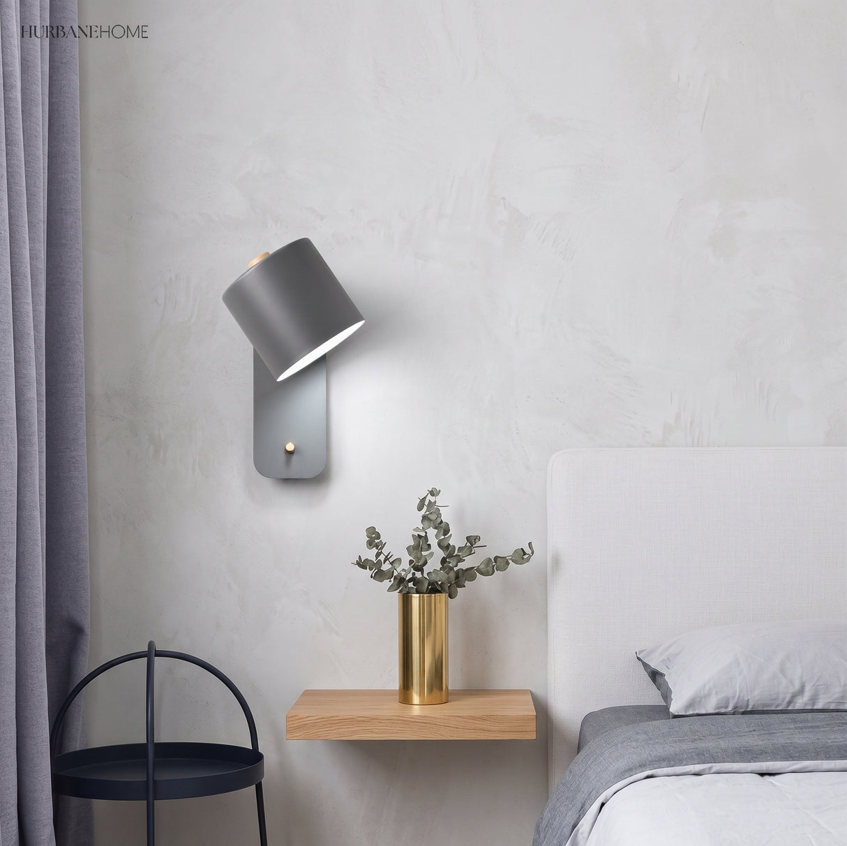 Rotatable cylinder wall sconce in a styled bedroom